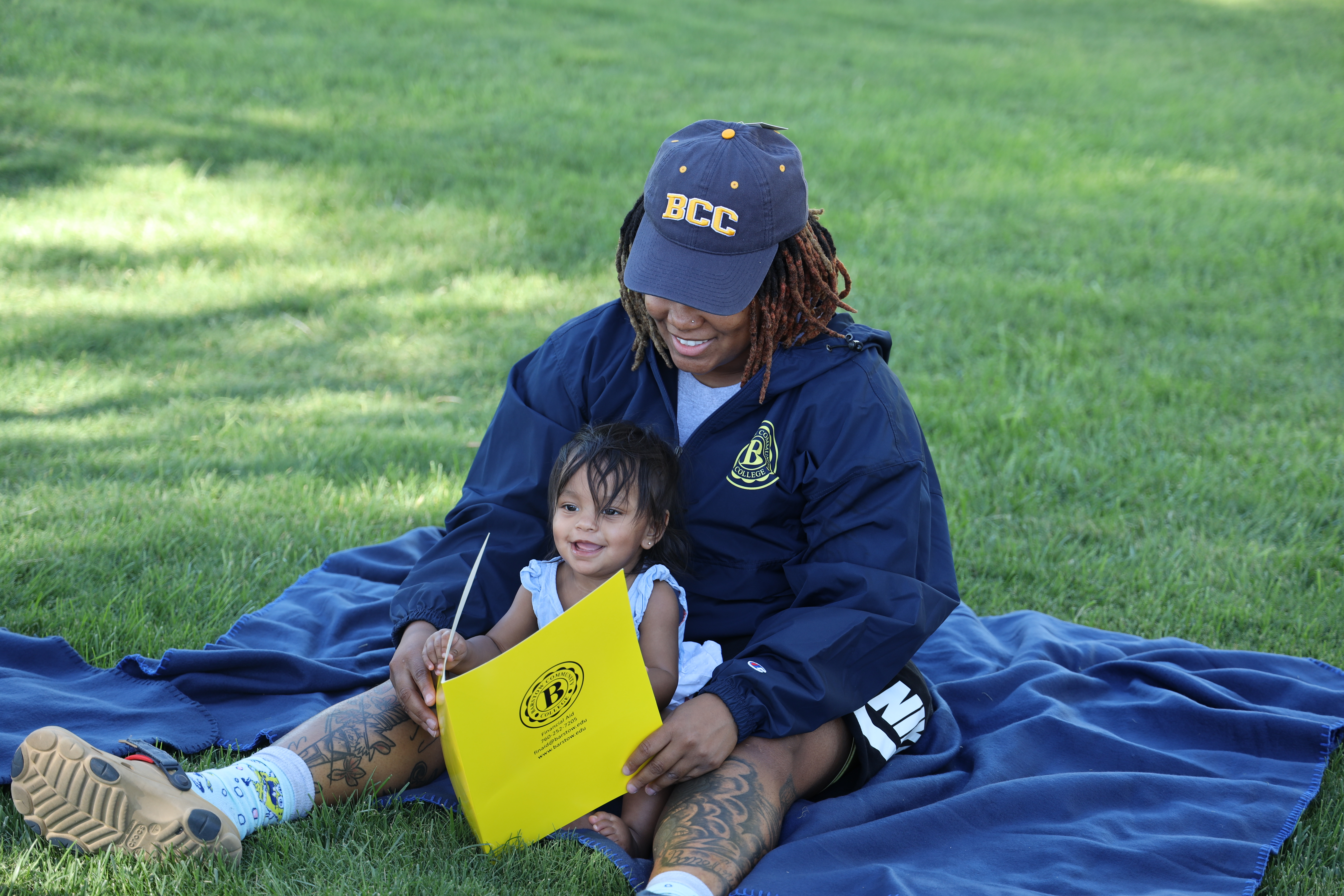 student leader reading to child on the lawn
